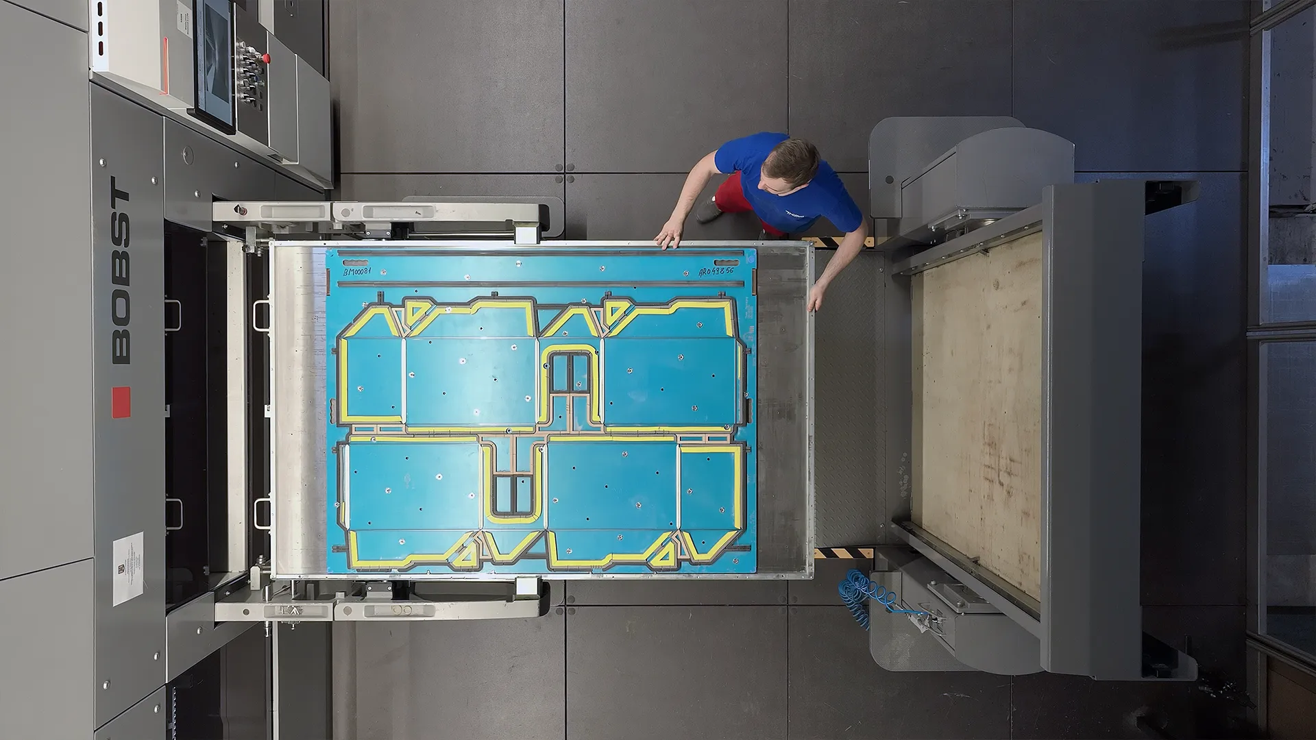 Ripresa zenitale di un operatore che inserisce una fustella nella MASTERCUT BOBST