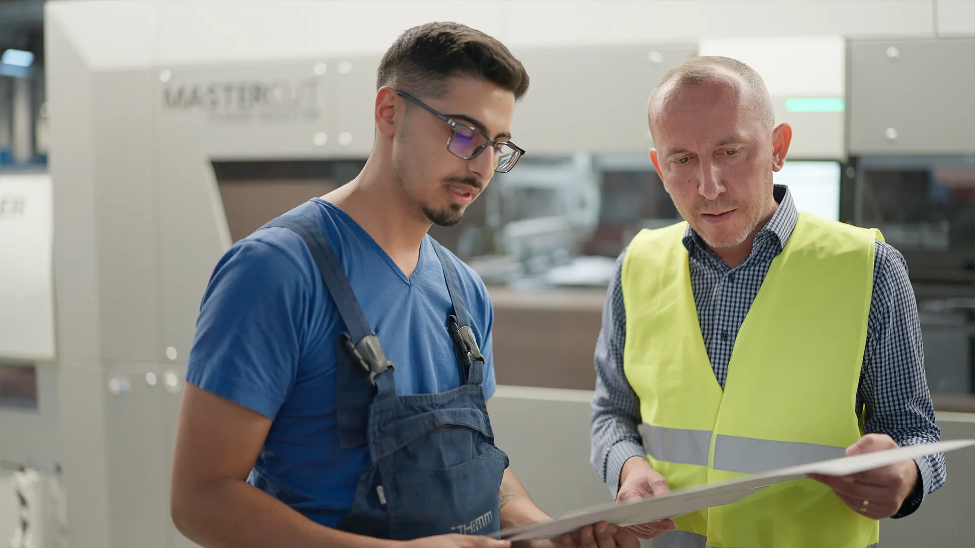Operatore e Plant Manager controllano un foglio fustellato davanti alla MASTERCUT BOBST